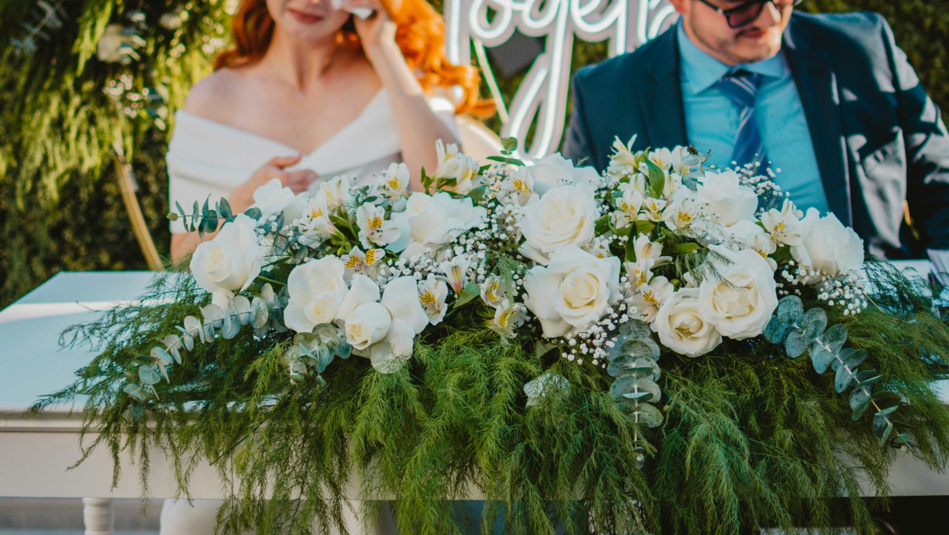 A couple signs a document at a wedding ceremony.